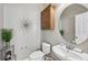 Half bathroom with a round mirror, a wooden storage cabinet, and decorative flower wall art at 505 Rendezvous Rd, Acworth, GA 30102