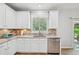 Bright kitchen featuring white cabinetry, stainless steel appliances, and granite countertops with a view to the outside at 505 Rendezvous Rd, Acworth, GA 30102