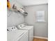 Laundry room equipped with a washer, dryer, and shelving for storage at 505 Rendezvous Rd, Acworth, GA 30102