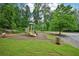 Neighborhood playground surrounded by lush trees, with benches and trash cans at 505 Rendezvous Rd, Acworth, GA 30102