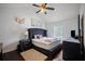 Comfortable bedroom featuring a large upholstered bed frame, ceiling fan, and hardwood flooring at 70 Fairclift Dr, Covington, GA 30016