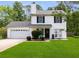 Charming two-story home featuring a well-manicured lawn, attached garage, and classic black shutters at 70 Fairclift Dr, Covington, GA 30016
