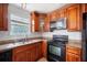 Functional kitchen featuring wood cabinets, granite countertops, and black appliances at 70 Fairclift Dr, Covington, GA 30016