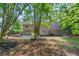A lush backyard view with mature trees surrounds the two-story home at 1368 Christiana Dr, Lawrenceville, GA 30043