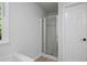 Bathroom with glass enclosed shower and tile surround near a white painted door at 1368 Christiana Dr, Lawrenceville, GA 30043