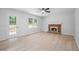 Living room with a brick fireplace, ceiling fan, and light-colored wood flooring at 1368 Christiana Dr, Lawrenceville, GA 30043