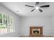 Living room with a brick fireplace, ceiling fan, and light-colored wood flooring at 1368 Christiana Dr, Lawrenceville, GA 30043