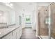 Bright bathroom featuring dual sinks, a walk-in shower, and soaking tub with window at 1471 Stephens View Dr, Loganville, GA 30052