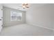 Carpeted, neutral-colored bedroom with ceiling fan and natural light at 1736 Dylan Pl, Lawrenceville, GA 30043