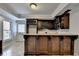 Basement wet bar with dark wood cabinets, granite countertop, and stylish wine rack at 340 Kincardine Way, Alpharetta, GA 30022