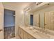 Well-lit bathroom with double vanity, marble countertops, and a view to the bedroom at 340 Kincardine Way, Alpharetta, GA 30022