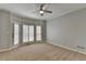 This bedroom features neutral carpet, gray walls, a ceiling fan, and large windows to let in natural light at 340 Kincardine Way, Alpharetta, GA 30022