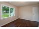 This bedroom features hardwood floors, neutral walls, a bright window view, and a classic interior door at 102 Peaceful Vw, Acworth, GA 30102
