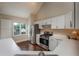 Bright kitchen features white cabinets, stainless steel appliances, and wood floors at 102 Peaceful Vw, Acworth, GA 30102