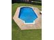 Backyard features a clean inground pool, surrounded by concrete and green grass at 102 Peaceful Vw, Acworth, GA 30102