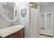 Bathroom with oval mirror, traditional vanity, and shower with bright white shower curtain at 111 Jeffrey Pl, Smyrna, GA 30082