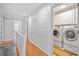 Upstairs hallway leading to a laundry room with white cabinets and updated machines at 111 Jeffrey Pl, Smyrna, GA 30082