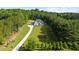 A long driveway through a landscaped yard that leads to a grand home surrounded by lush greenery at 2400 Worth Ave, Loganville, GA 30052