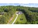 Aerial view of an estate with a sprawling lawn, long driveway, and mature trees at 2400 Worth Ave, Loganville, GA 30052