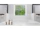 Soaking tub featuring a window, hardwood floors, and dual vanities at 2400 Worth Ave, Loganville, GA 30052