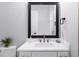 Clean bathroom showcasing a framed mirror, vanity, and marble countertops at 2400 Worth Ave, Loganville, GA 30052