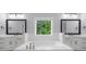 Bright bathroom featuring dual sink vanities, a soaking tub and hardwood floors at 2400 Worth Ave, Loganville, GA 30052