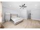 A spacious bedroom featuring light walls, ceiling fan, light hardwood floors and a queen sized bed at 2400 Worth Ave, Loganville, GA 30052