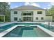 Home exterior with a pool, lounge seating, lush green landscaping, and a backdrop of mature trees at 2400 Worth Ave, Loganville, GA 30052