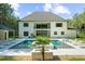 Home exterior with a pool, lounge seating, lush green landscaping, and a backdrop of mature trees at 2400 Worth Ave, Loganville, GA 30052