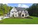 Elegant two-story home with a mix of stone and painted brick, complemented by a vibrant green lawn at 2400 Worth Ave, Loganville, GA 30052