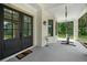 Covered front porch featuring double doors, a welcome mat, brick columns and a porch swing at 2400 Worth Ave, Loganville, GA 30052