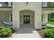 Inviting front porch with stone columns and hammocks, leading to a home's entrance at 2400 Worth Ave, Loganville, GA 30052