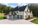 Side view of a home with a three-car garage and a large concrete driveway and well-manicured landscaping at 2400 Worth Ave, Loganville, GA 30052