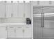 Close up view of a refrigerator and white cabinets in a kitchen with marble countertops at 2400 Worth Ave, Loganville, GA 30052