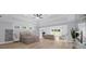 Open main bedroom featuring hardwood floors, tray ceilings, windows, and a decorative fireplace at 2400 Worth Ave, Loganville, GA 30052