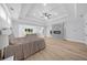 Open main bedroom featuring hardwood floors, tray ceilings, a modern fireplace, and access to the living room at 2400 Worth Ave, Loganville, GA 30052