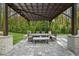 Outdoor dining area with a pergola, built-in grill, dining table, and lush backyard at 2400 Worth Ave, Loganville, GA 30052