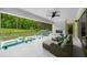 Covered patio with a ceiling fan overlooking the pool and greenery at 2400 Worth Ave, Loganville, GA 30052