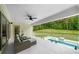 Covered patio with outdoor seating area overlooking the pool and trees at 2400 Worth Ave, Loganville, GA 30052