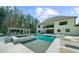 Luxury home exterior with an in-ground pool, spa, outdoor kitchen, and spacious patio at 2400 Worth Ave, Loganville, GA 30052