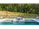 Outdoor pool with jacuzzi and waterfall feature with a lush green backdrop at 2400 Worth Ave, Loganville, GA 30052