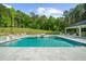 Outdoor pool with jacuzzi and waterfall feature with a lush green backdrop at 2400 Worth Ave, Loganville, GA 30052