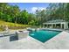 Outdoor pool with jacuzzi and waterfall feature with a lush green backdrop at 2400 Worth Ave, Loganville, GA 30052
