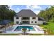 Stunning rear exterior view of a modern home with a pool and manicured lawn at 2400 Worth Ave, Loganville, GA 30052