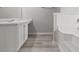 Bright bathroom featuring a vanity with storage and tub with white tile surround at 331 Overlook Turn Nw, Conyers, GA 30012