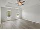 Bedroom with tray ceilings, a ceiling fan, and gray wood flooring at 331 Overlook Turn Nw, Conyers, GA 30012