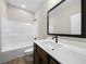 Modern bathroom featuring a dark vanity, framed mirror and a tub-shower combination with chrome fixtures at 389 Campground School Rd, Dallas, GA 30157