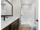 Bright bathroom featuring a tub-shower combo with dark fixtures, a modern vanity, and wood-look flooring at 389 Campground School Rd, Dallas, GA 30157