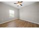 Bright bedroom with wood-look floors, ceiling fan, and a window showcasing the outdoor view at 389 Campground School Rd, Dallas, GA 30157