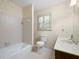 Bathroom showcasing patterned wallpaper, a shower-tub combo, and white tile at 2101 Breconridge Sw Dr, Marietta, GA 30064